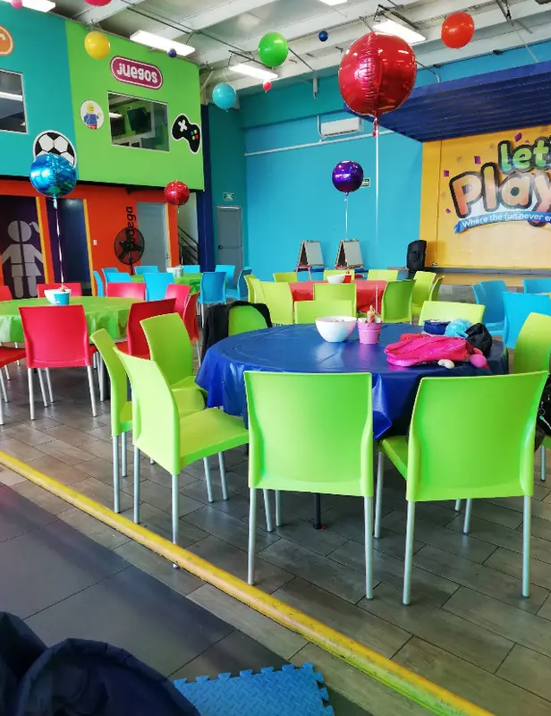 Mesas y escenario con el logo de Let's Play